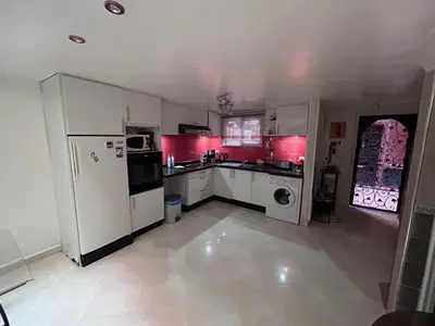 a kitchen with white appliances and pink cabinets at Riad le pélican in Marrakech