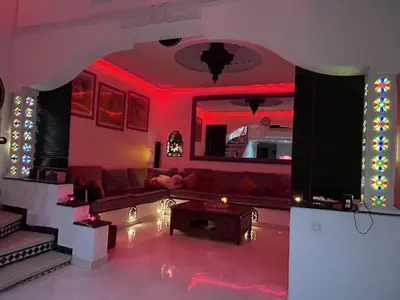 a living room with a couch and red lighting at Riad le pélican in Marrakech