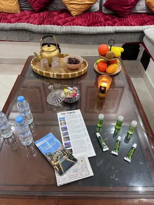 a glass table with a tea pot and fruit on it at Riad le pélican in Marrakech