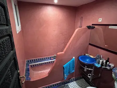 a bathroom with a tub and a blue sink at Riad le pélican in Marrakech