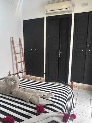 a bedroom with a bed with black doors at Riad le pélican in Marrakech