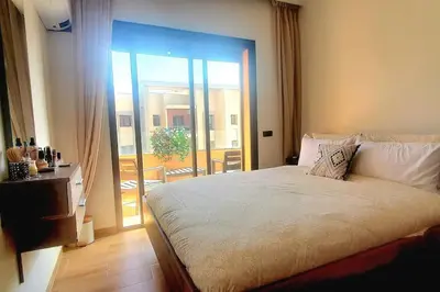 a bedroom with a bed and a sliding glass door at Super appartement haut standing centre gare in Marrakech