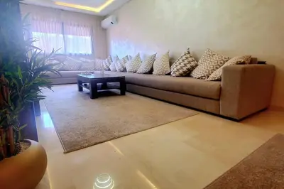 a living room with a couch and a table at Super appartement haut standing centre gare in Marrakech
