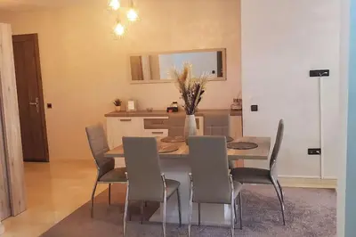 a kitchen and dining room with a table and chairs at Super appartement haut standing centre gare in Marrakech