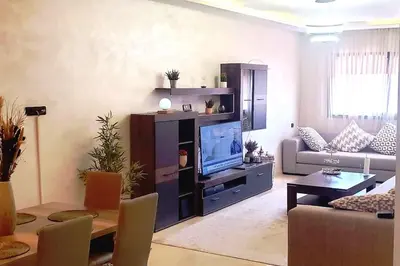 a living room with a large entertainment center with a television at Super appartement haut standing centre gare in Marrakech