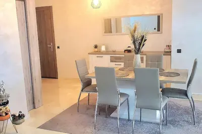 a kitchen and dining room with a table and chairs at Super appartement haut standing centre gare in Marrakech
