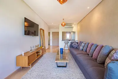 a living room with a couch and a table at Golf Prestigia, grande piscine, jardins in Marrakech