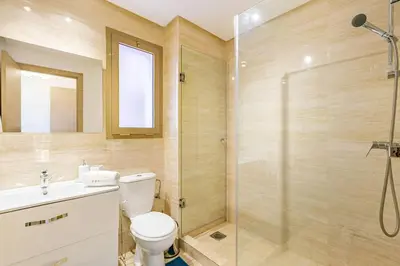 a bathroom with a shower and a toilet and a sink at Golf Prestigia, grande piscine, jardins in Marrakech