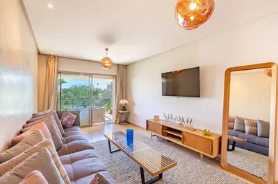 a living room with a couch and a mirror at Golf Prestigia, grande piscine, jardins in Marrakech