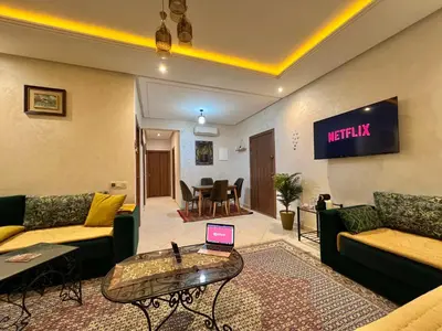 a living room with a couch and a laptop on a table at Cosy luxe RB Marrakech in Marrakech