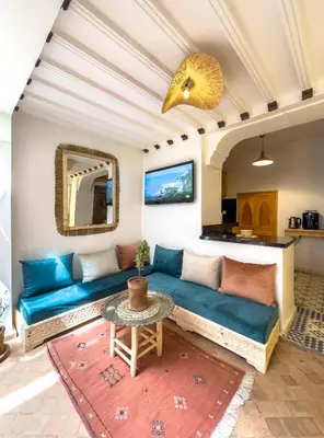 a living room with a blue couch and a table at Riad & SPA Privé - La Perle d'Orane - Marrakech in Marrakech