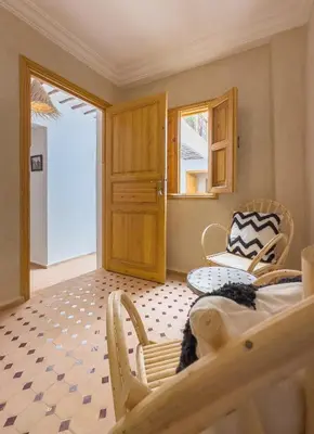 a room with a bed and a table and chairs at Riad & SPA Privé - La Perle d'Orane - Marrakech in Marrakech