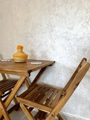 a wooden table and chair with a vase on it at Cozy Apartment In Marrakech in Marrakech