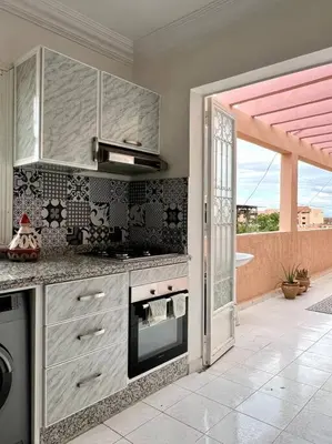 a kitchen with a stove top oven next to a window at Cozy Apartment In Marrakech in Marrakech