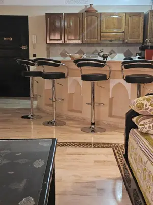 a kitchen with four bar stools and a counter at APPARTEMENT DOUILLET AU CENTRE GUELIZ in Marrakech