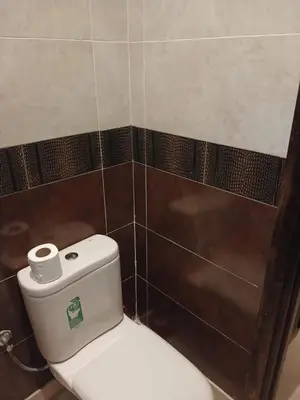 a white toilet in a bathroom with brown tiles at Villa Mima in Marrakech