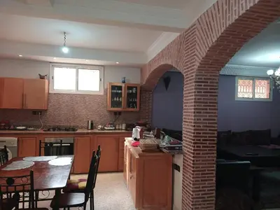 a kitchen with a table and a brick wall at Villa Mima in Marrakech