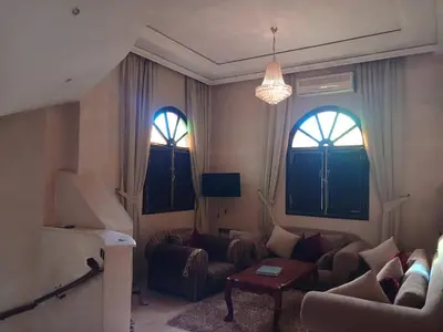 a living room with a couch and two windows at Villa Mima in Marrakech