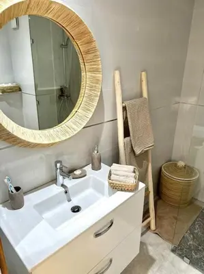 a bathroom with a white sink and a mirror at Appartement Luxe Riad Garden Marrakech 3 piscines in Marrakech