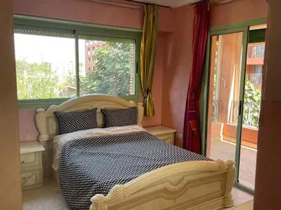 a bedroom with a bed and a large window at Appartement de prestige au quartier de l’Hivernage, Marrakech in Marrakech