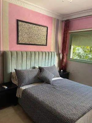 a bedroom with a bed with a large headboard at Appartement de prestige au quartier de l’Hivernage, Marrakech in Marrakech