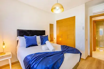 a bedroom with a large bed with blue and white pillows at Prestigia Saphir,Piscine, Jardin in Marrakech