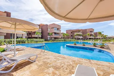 an image of a swimming pool with chairs and an umbrella at Prestigia Saphir,Piscine, Jardin in Marrakech