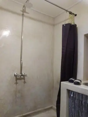 a bathroom with a shower and a shower curtain at Riad Bouganville Bleu in Marrakech