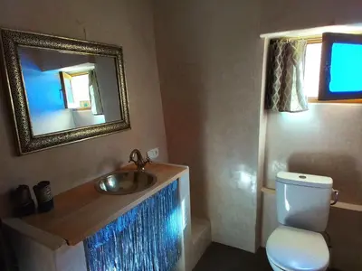 a bathroom with a sink and a toilet and a mirror at Riad Bouganville Bleu in Marrakech