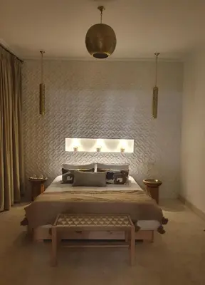 a bedroom with a king sized bed and a table at Riad Fisaline en exclusivité pour vous à Marrakech in Marrakech