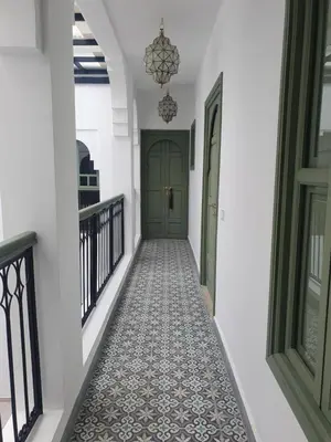 a hallway with a green door and a tile floor at Riad Fisaline en exclusivité pour vous à Marrakech in Marrakech