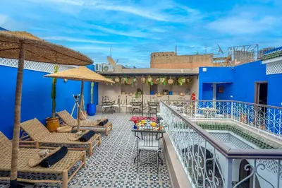 a balcony with chairs and a table and a swimming pool at Riad Tarba & Spa in Marrakech