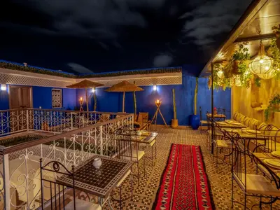 a restaurant with blue walls and tables and a red carpet at Riad Tarba & Spa in Marrakech