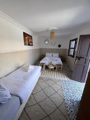 a bedroom with two beds and a table in it at Riad Tarba & Spa in Marrakech