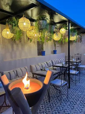 a restaurant with tables and chairs with a fire pit at Riad Tarba & Spa in Marrakech