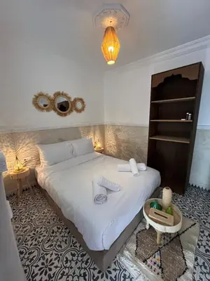 a bedroom with a large white bed and a table at Riad Tarba & Spa in Marrakech