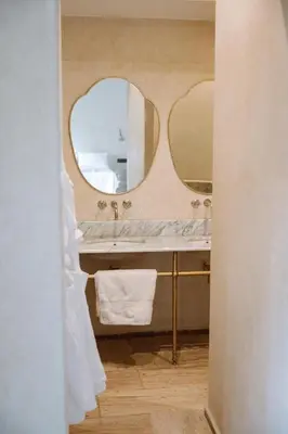a bathroom with two mirrors and a sink at Riad Le Sable Vert in Marrakech