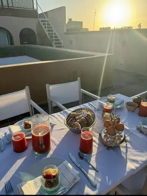 a table with a blue table cloth with food on it at Riad Le Sable Vert in Marrakech