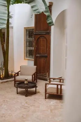 a room with two chairs and a table and a door at Riad Le Sable Vert in Marrakech