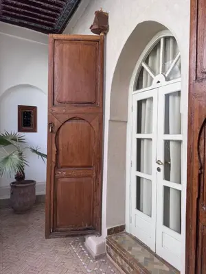an entrance to a house with a wooden door at Riad Le Sable Vert in Marrakech