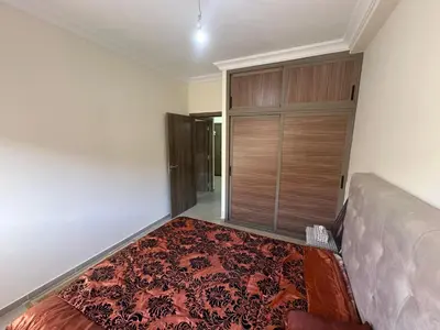 a living room with a bed and a rug at Marrakech airport apartment in Marrakech