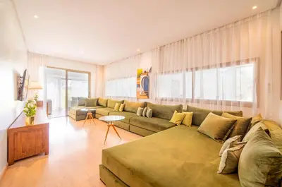 a living room with a green couch and a table at Central & comfy 3BR apartment with pool & wifi access in Marrakech
