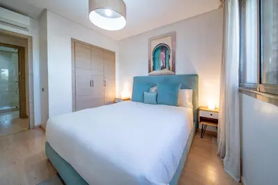 a bedroom with a large white bed and a window at Central & comfy 3BR apartment with pool & wifi access in Marrakech
