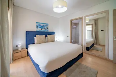 a bedroom with a large bed with a blue headboard at Central & comfy 3BR apartment with pool & wifi access in Marrakech