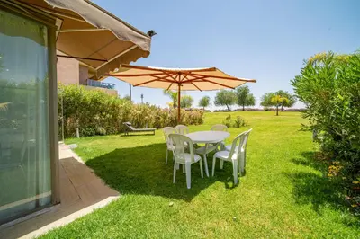 a table and chairs under an umbrella in a yard at Central & comfy 3BR apartment with pool & wifi access in Marrakech