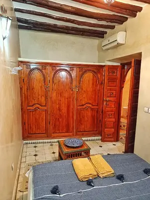 a bedroom with a large wooden cabinet and a bed at Medina house in Marrakech