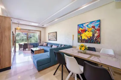 a living room with a blue couch and a table at Apart Confort Front Pool-Garden in Marrakech