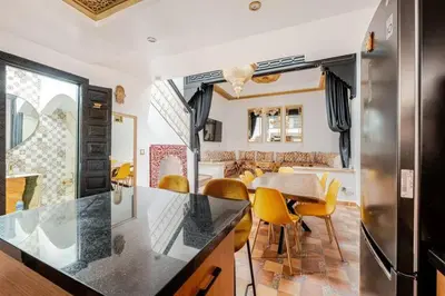 a kitchen and dining room with a table and yellow chairs at 16 Riads in Marrakech