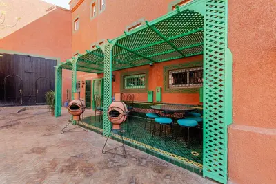a patio with a bar with stools and a table at 16 Riads in Marrakech