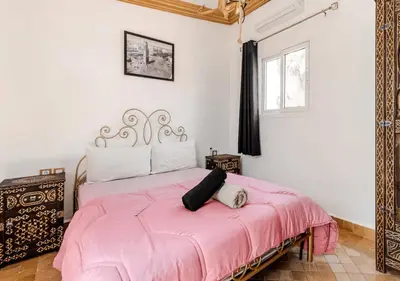a bedroom with a pink bed and a window at 16 Riads in Marrakech